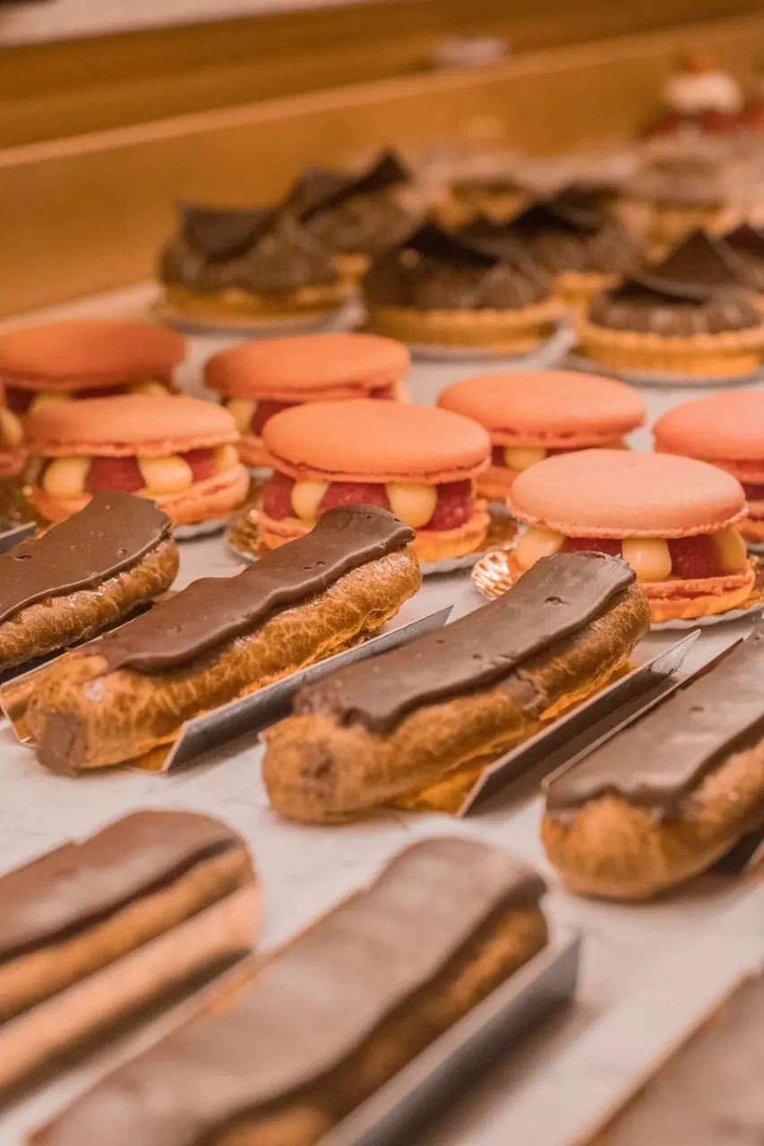 Artisan chocolate eclairs and delicate fruit tarts in a bakery display