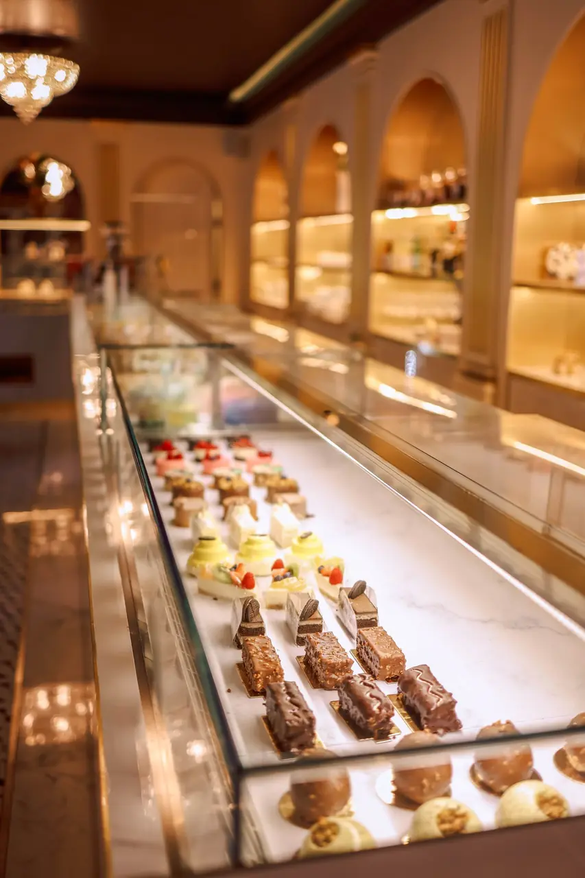 Atmospheric patisserie counter with warm lighting and fresh morning bakes