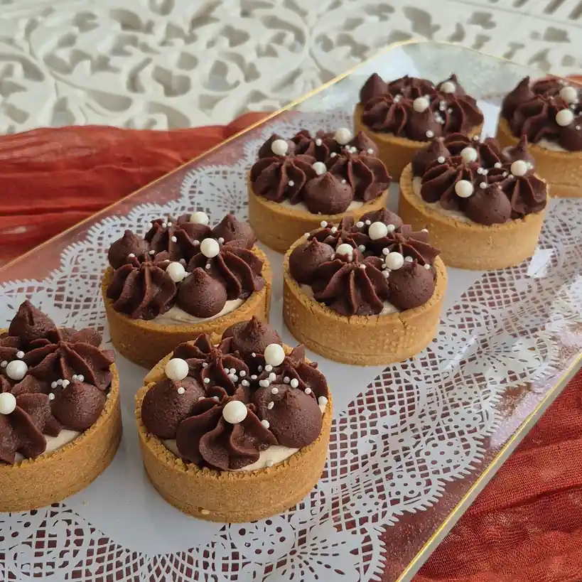 Handcrafted chocolate crémeux tart with delicate quenelle and gold leaf finish
