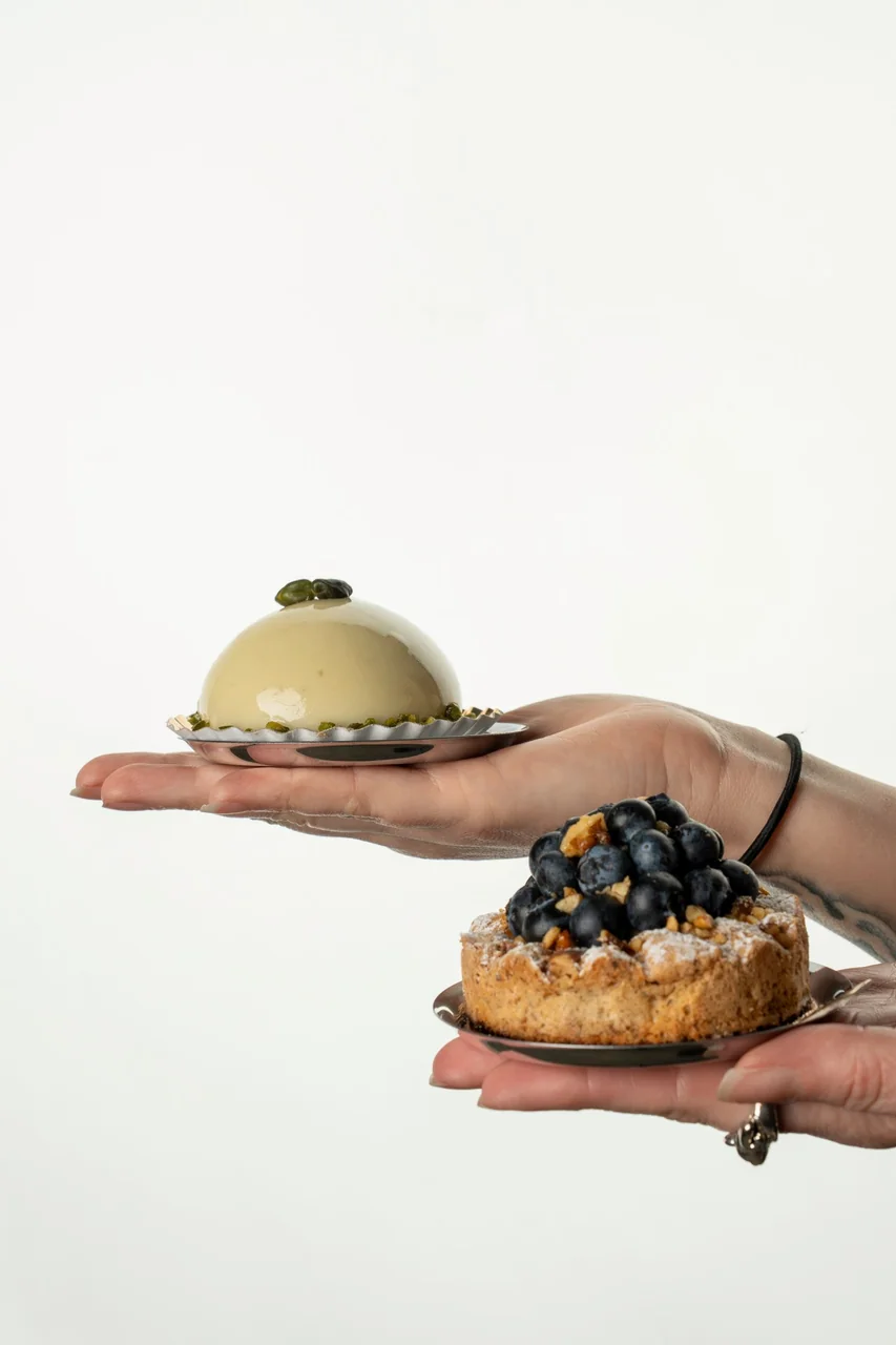 Close-up of chef hands presenting refined French patisserie creation