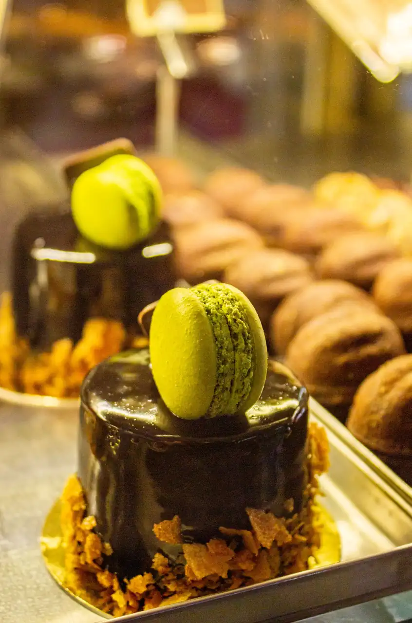 Dark chocolate gateau with mirror glaze and pistachio macaron garnish