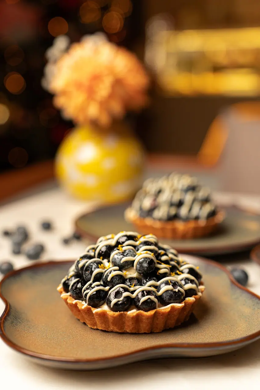 Seasonal fresh berry tartlets arranged on ceramic dishware